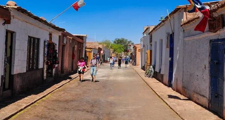 Escena callejera en un pueblo con gente caminando.