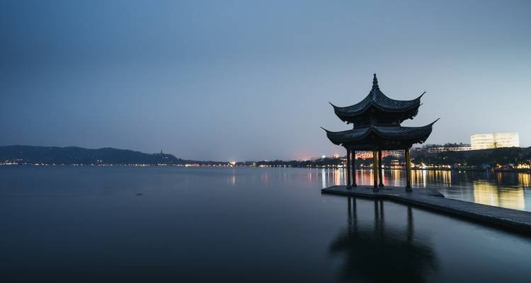 Pagoda tradicional junto a un lago tranquilo al atardecer.