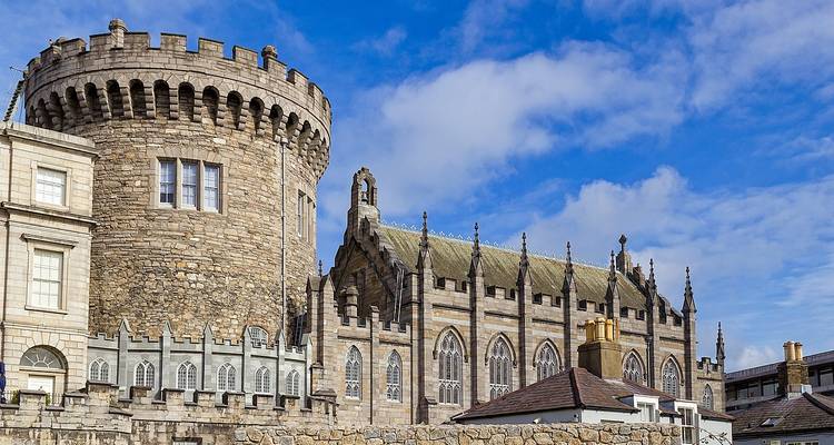 La tour des archives médiévale et la chapelle gothique du château de Dublin se dressent contre un ciel bleu éclatant.