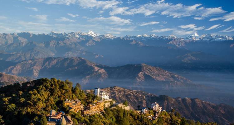 Luchtfoto van bergketen met dorpen en valleien in het groen.