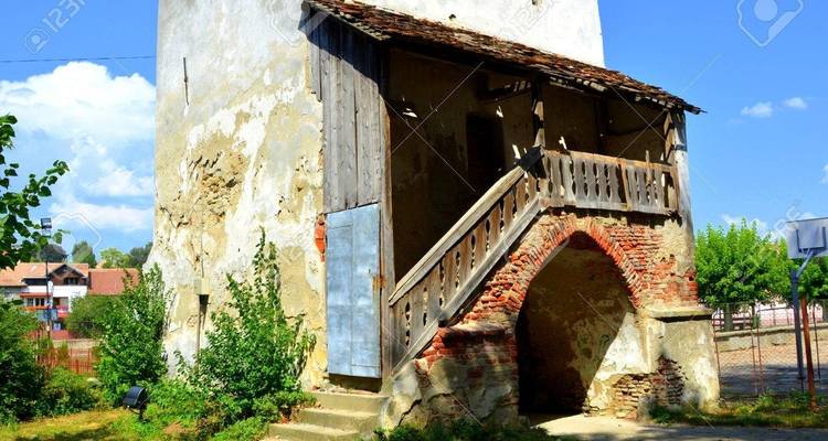 Alter Wachturm mit Holztreppe und einem Wasserzeichen.