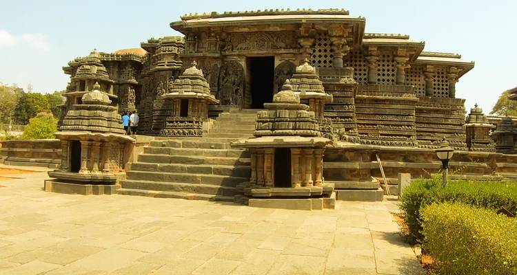 Entrée d'un temple historique avec des structures en pierre détaillées et des gens.