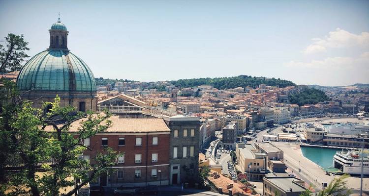 Stadsgezicht met een koepelkerk en rivier op de voorgrond