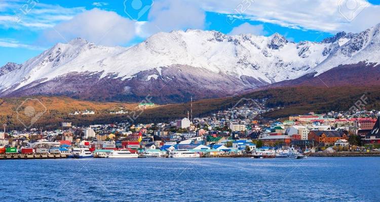Cityscape with snowy mountains and sea.
