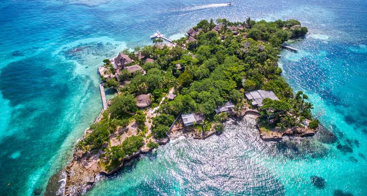 Vue aérienne d'une île luxuriante entourée d'eaux turquoise.