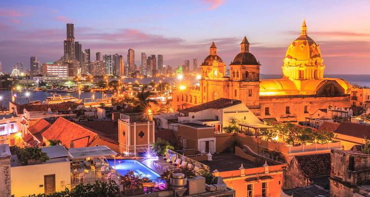 Vue du coucher de soleil sur Carthagène, avec des bâtiments historiques et modernes.