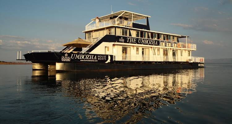 Woonboot genaamd The Umbozha op een kalm meer bij zonsondergang.