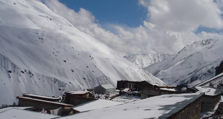 Sneeuwbedekt berglandschap met gebouwen aan de voet.