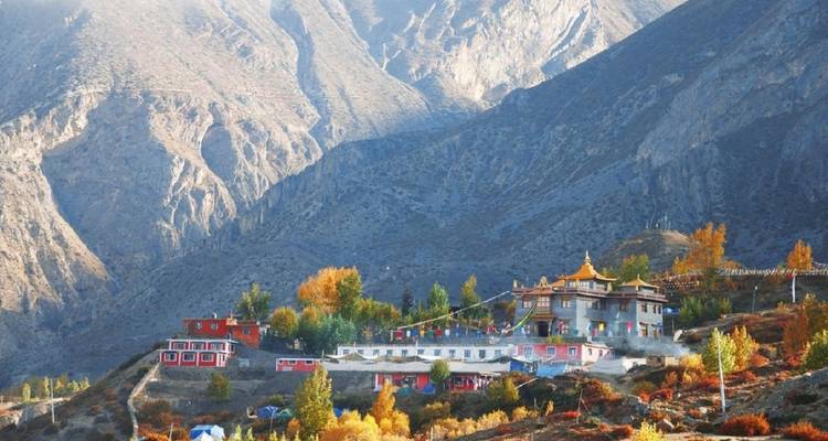 Kleurrijk dorp genesteld in de bergen met herfstkleuren.