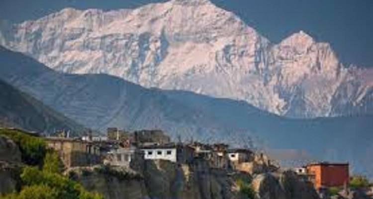 Bergstadje met sneeuwbedekte toppen op de achtergrond.