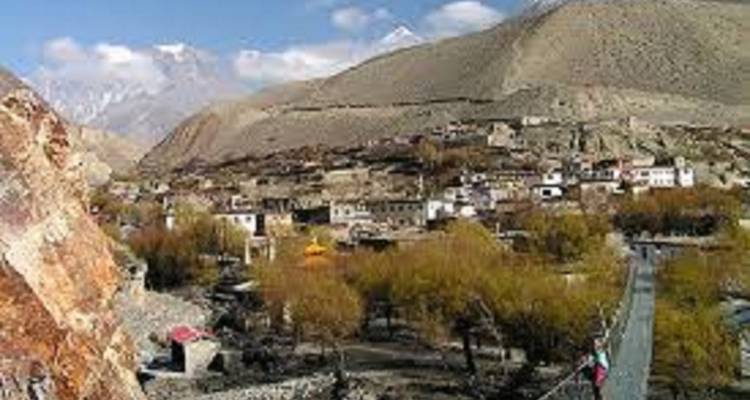 Stad met kleine gebouwen en een brug in een vallei.