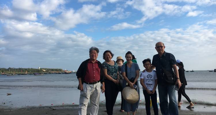Family photo on a sandy beach with a sea view.
