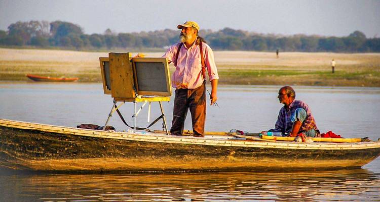 Dos hombres en un barco, uno mirando a la distancia.