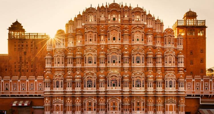 Zonlicht dat door de architectuur van een imposante gevel gluurt.