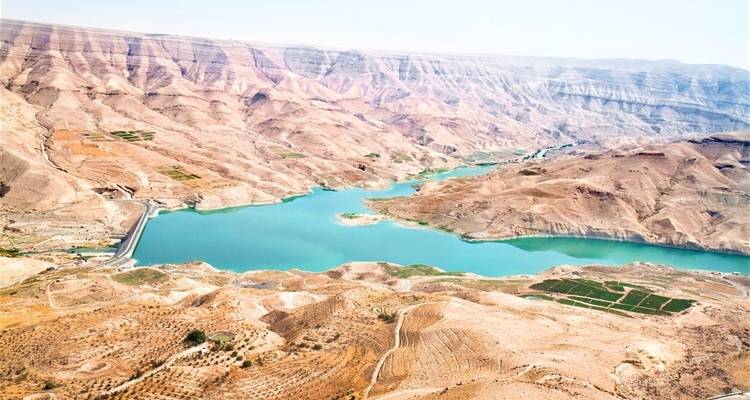 Luftaufnahme eines Wasserreservoirs umgeben von einer trockenen Landschaft.