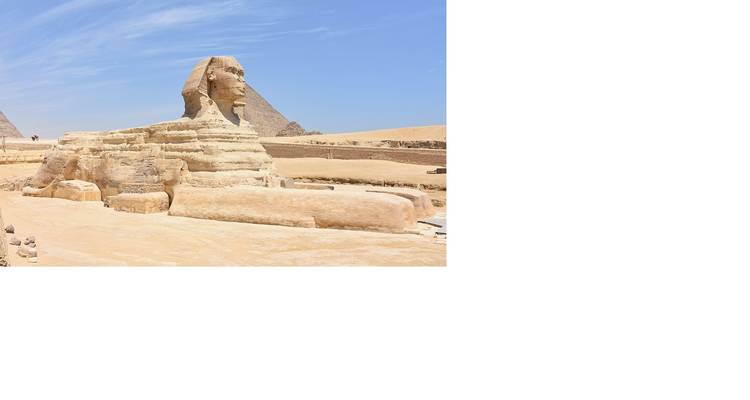 Seitenansicht der Sphinx mit Pyramiden und Wüstenlandschaft in Kairo.