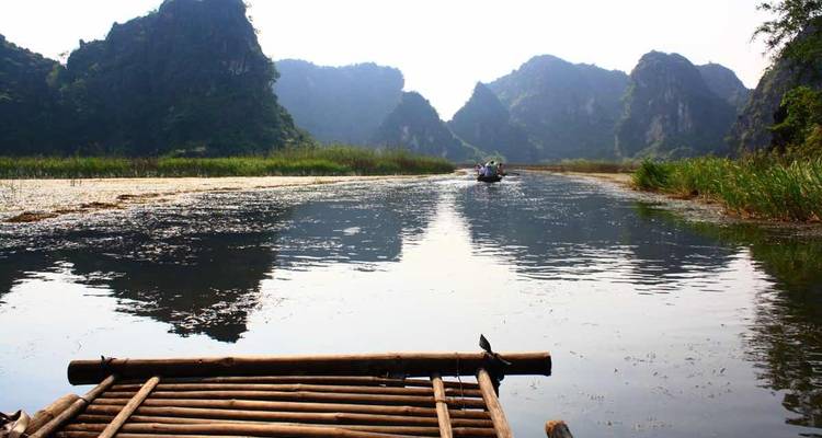 Blick von einem Floß auf einem Fluss mit Kalksteinformationen in der Ferne.
