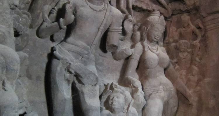 Antike Steinreliefs, die Gottheiten in einem Höhlentempel darstellen.