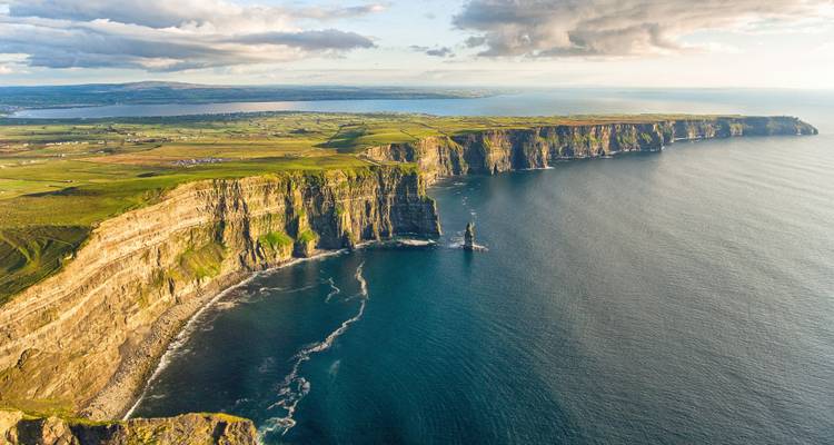 Vue aérienne de falaises emblématiques le long d'une côte escarpée.