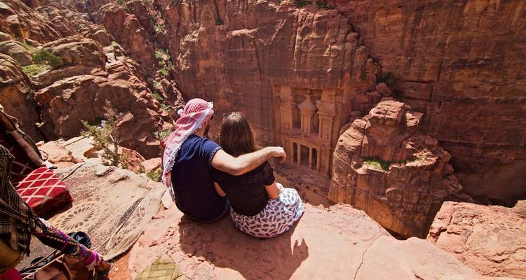 Paar sitzt auf Felsen mit Blick auf das Schatzhaus.