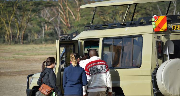 Gruppe von Menschen, die sich darauf vorbereitet, in ein Safari-Fahrzeug einzusteigen.