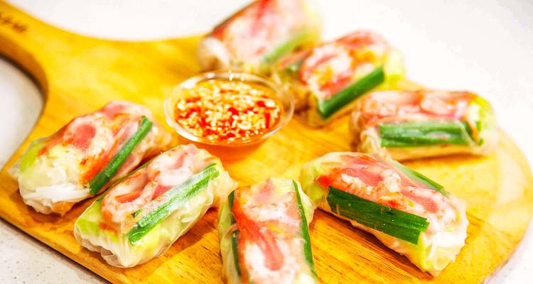 Vietnamese loempia's gerangschikt op een houten schaal met saus.