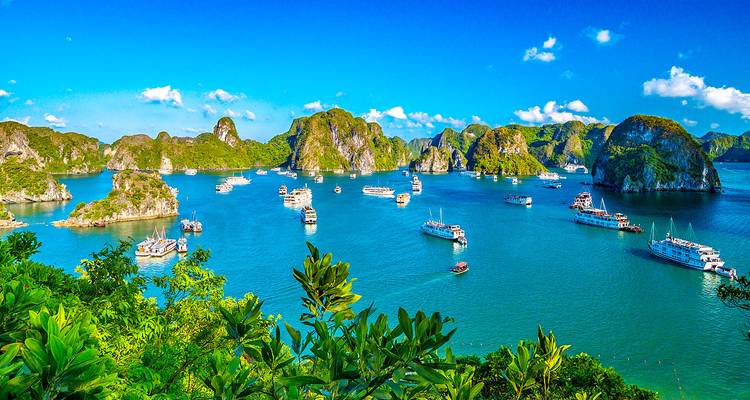 Een schilderachtig uitzicht op Halong Bay met boten verspreid over turkooizen wateren.