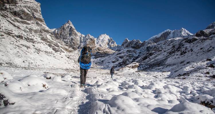 Wandelaar loopt over besneeuwde bergpaden.