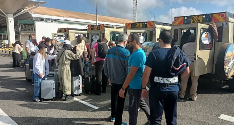 Un groupe de voyageurs avec des bagages attendant près de jeeps de safari.