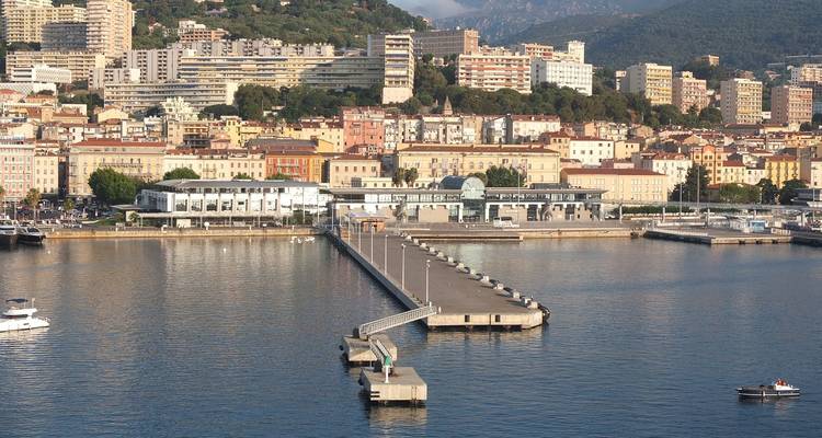 Un paysage urbain côtier coloré avec une jetée s'étendant dans l'eau.