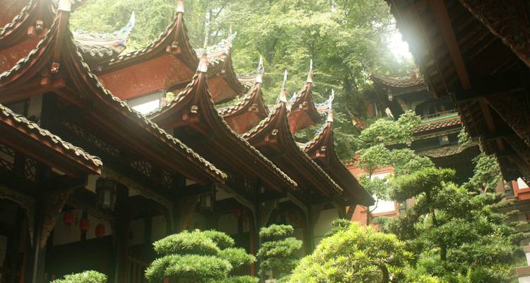 Templo tradicional chino con techos en capas y exuberante vegetación en el patio
