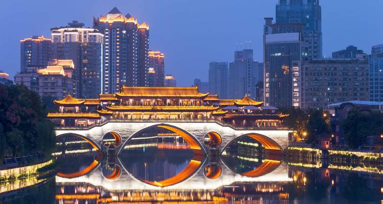 El Puente Anshun y su reflejo brillan sobre el Río Jin contra el horizonte de Chengdu al atardecer