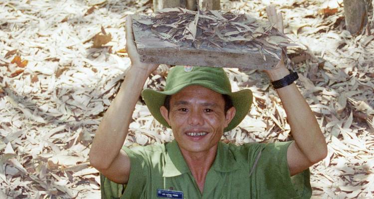 Person holding a wooden trap and smiling.