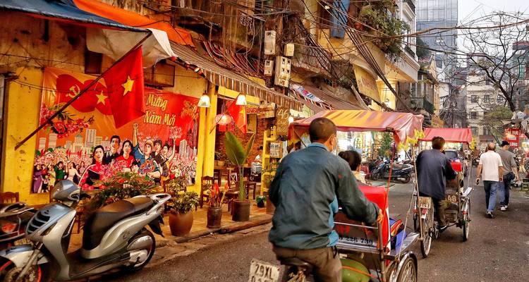 Bustling street in Hanoi with people on bikes.