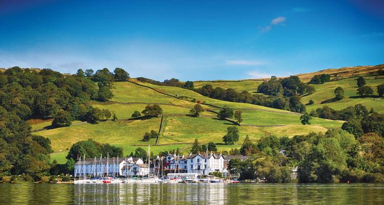 Seestadt mit sanften Hügeln und einem klaren blauen Himmel.
