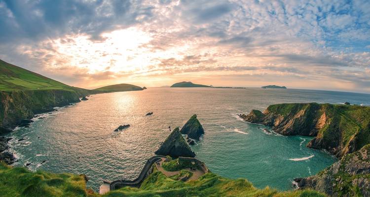 Côte pittoresque avec falaises et îles au coucher du soleil.