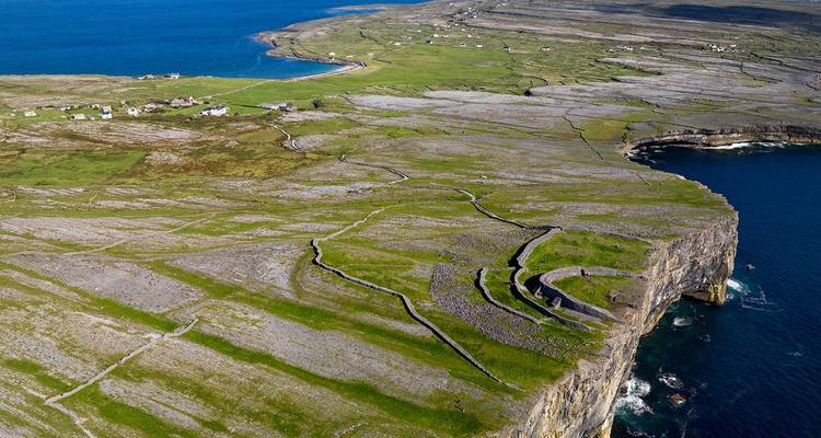 Vue aérienne de l'île d'Inis Mór avec des falaises et un paysage verdoyant.
