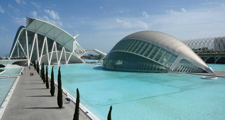 Las estructuras blancas futuristas y las piscinas turquesas de la Ciudad de las Artes y las Ciencias de Valencia relucen bajo un cielo despejado.