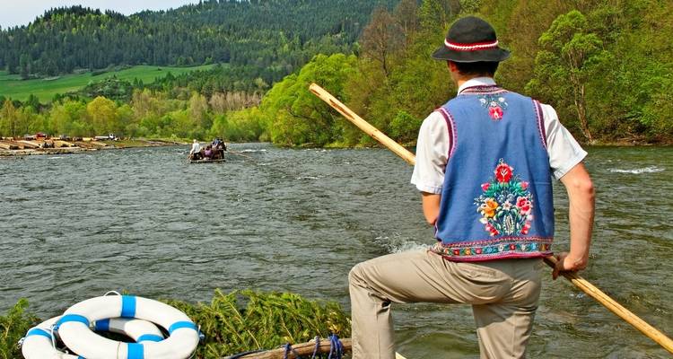 Person in traditional attire rafting on a river.