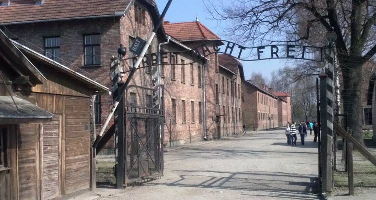 Here's the Dutch translation:

**Auschwitz toegangspoort met historische betekenis.**

Alternative translation:
**Auschwitz ingangspoort met historische betekenis.**

Both "toegangspoort" and "ingangspoort" are correct Dutch translations for "entry gate."