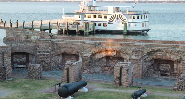 Ruines d'un fort historique avec des canons au bord de l'eau.