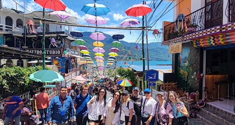 Groupe de touristes dans une rue avec des parapluies suspendus.