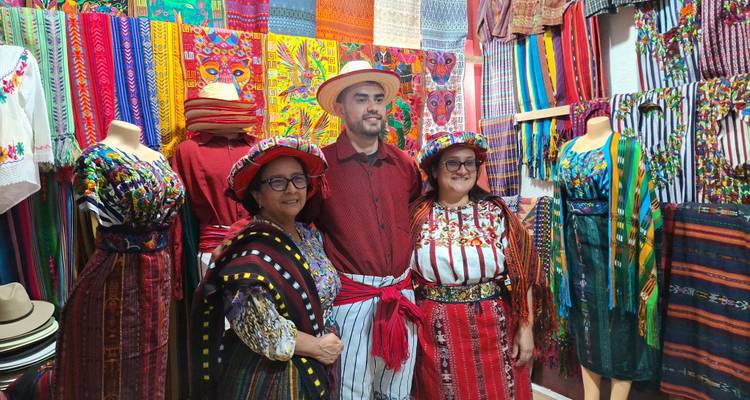 Des gens vêtus de vêtements traditionnels à l'intérieur d'une boutique de textiles colorée.