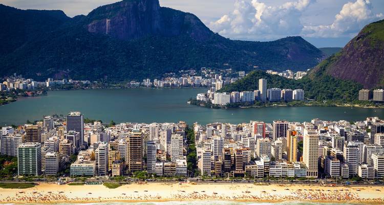 Luftaufnahme einer von Bergen und Seen umgebenen Stadt.