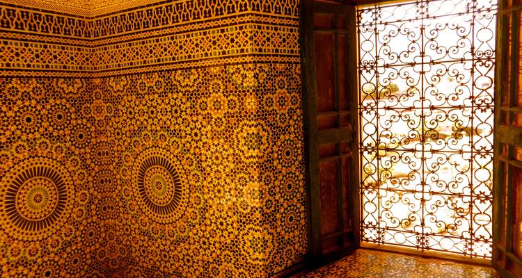 Aufwendig gefliester Raum mit kunstvollen Fenstergittern und hellem Sonnenlicht.