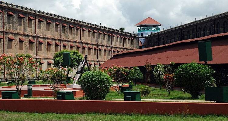 Oud koloniaal gevangenisgebouw met planten.