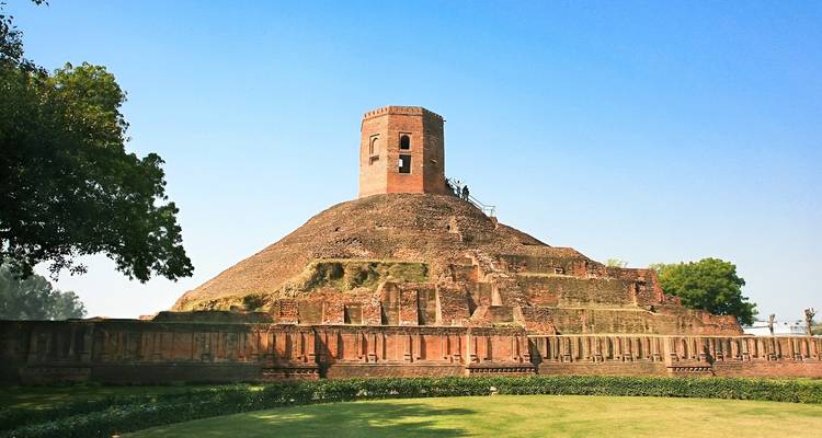 Here is the translation from English to Dutch:

"Oude stupa-structuur omgeven door weelderig groen."
