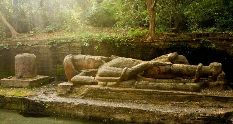Stenen beeldhouwwerken in een bosgebied.