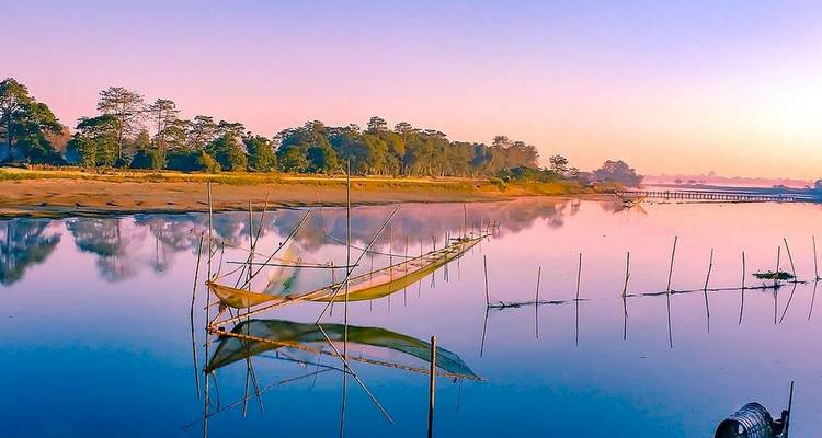 Calm river with fishing nets and trees along the bank.