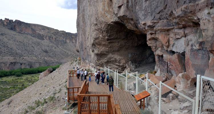 Bezoekers die langs een boardwalk bij kliffen wandelen.